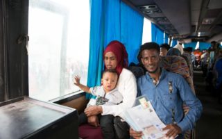 A family rides on a bus in Libya while holding documents
