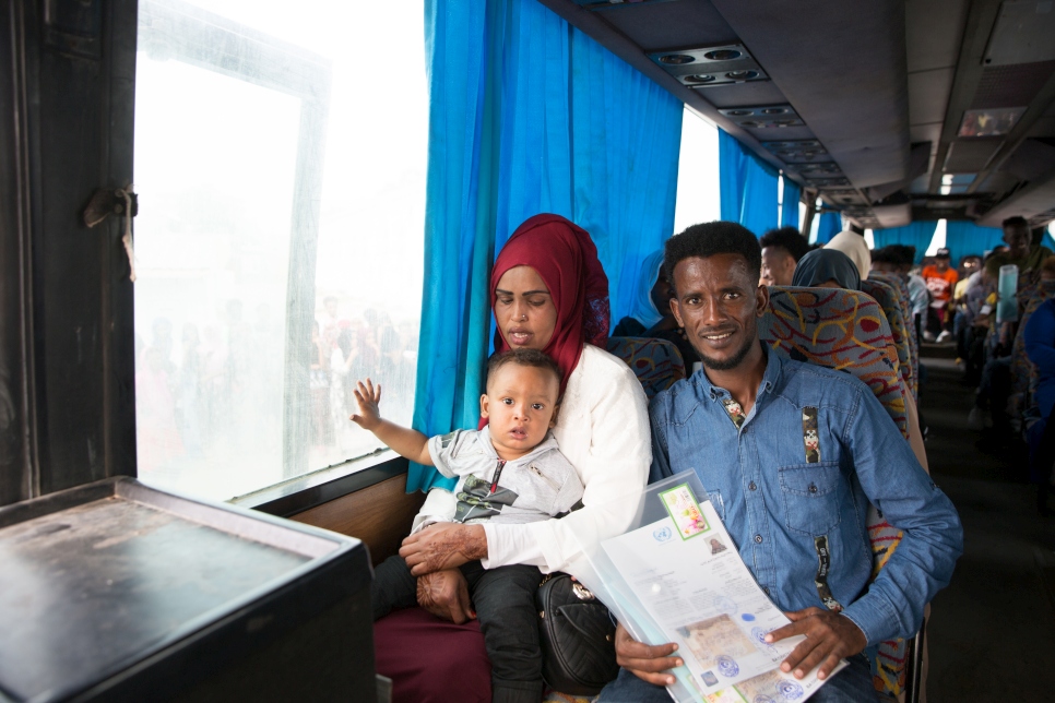 A family rides on a bus in Libya while holding documents