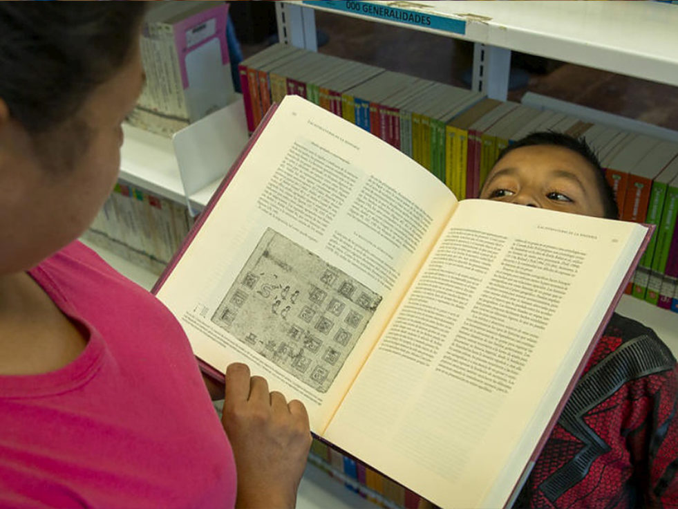 A woman reads her son a book in Mexico