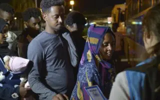 A man and a woman wait to get onto a bus in Libya