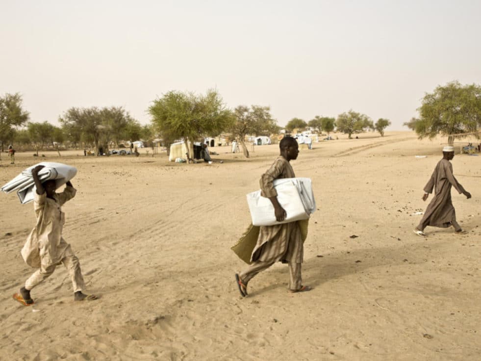 Three refugees from Nigeria cross a desert in Niger