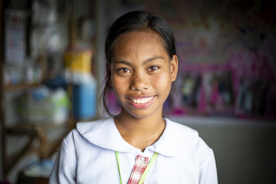 A young girl smiles in her home in the Philippines