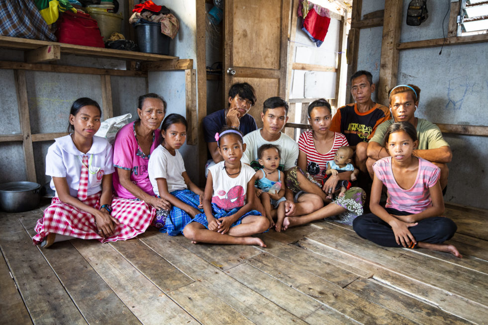 A family sits in their home in the Philippines