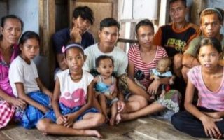 A family sits in their home in the Philippines