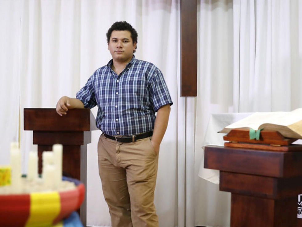 A Nicaraguan lawyer stands beside a podium and poses