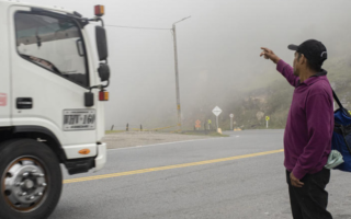 A hitchhiking Venezuelan man attempts to hail down a large truck