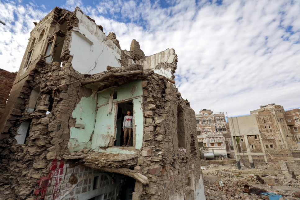 Yemeni child stands in the ruins of a building