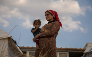 A refugee in Iraq holds her child