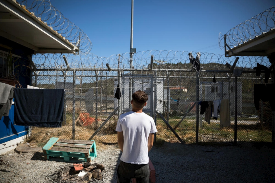 A boy on Lesvos island looks at a camp