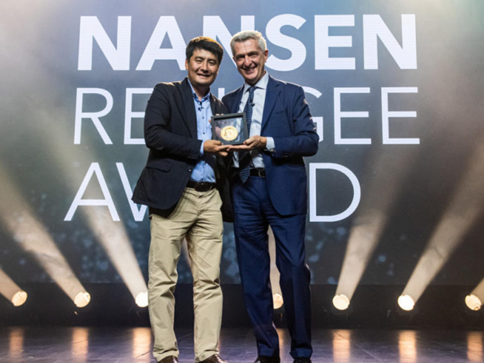 The Nansen refugee award winner smiles with the high commissioner as he receives his award