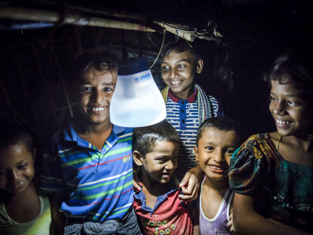 Rohingya boys hold a solar lamp that is sustainable