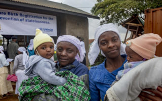 Two women who were stateless hold their children