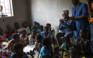 Refugee Chief sits with children in Zambia