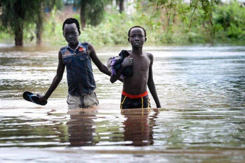 Two boys pick their way along a flooded road in Maban county, South Sudan