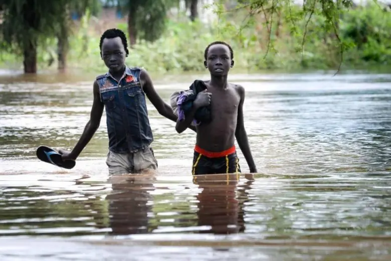 Two boys pick their way along a flooded road in Maban county, South Sudan