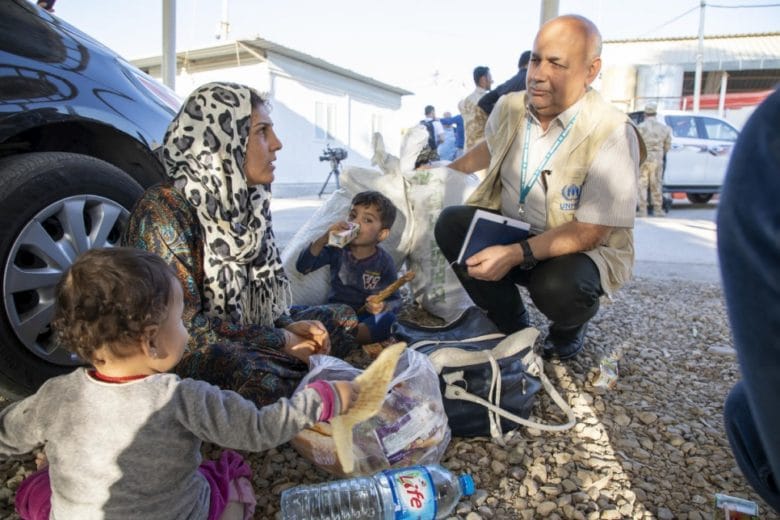 Un employé du HCR en charge de la protection s’entretient avec des réfugiés syriens nouvellement arrivés au camp de réfugiés de Domiz, dans la région du Kurdistan irakien. 