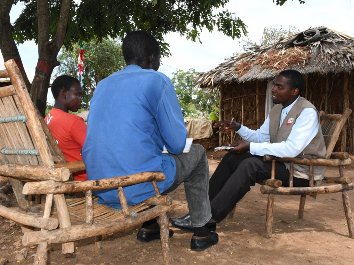 Jedah Twebaze (à droite), infirmier ougandais spécialiste du VIH, discute avec Inga Viola (à gauche) et Rufas Taban, réfugiés sud-soudanais, dans l’installation de réfugiés d’Imvepi