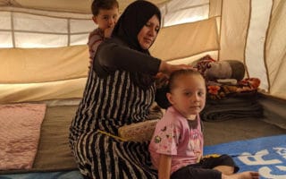 Nadira, une réfugiée syrienne, coiffe sa fille dans leur tente du camp de Bardarash, dans le gouvernorat de Dohouk