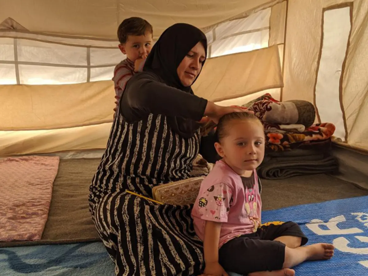 Les Syriens coiffe sa fille dans leur tente du camp de Bardarash, dans le gouvernorat de Dohouk