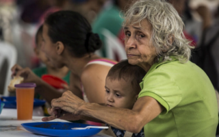 A Venezuelan grandmother and her grandson eat a meal at a community kitchen in Cúcuta, Colombia