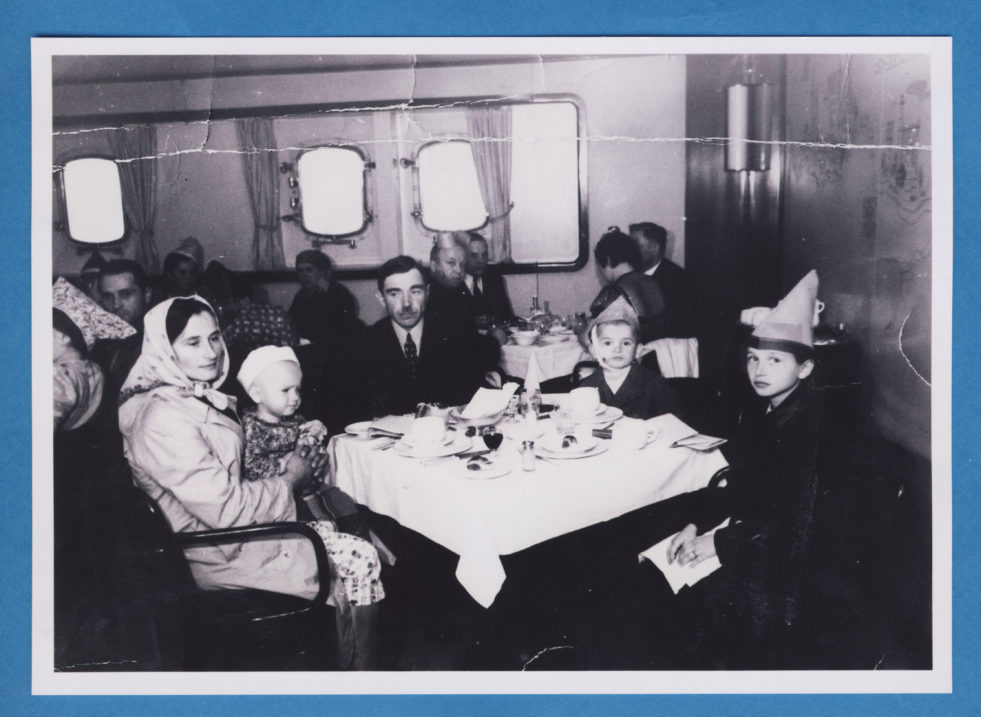 A black and white image of people sitting around a table in Canada