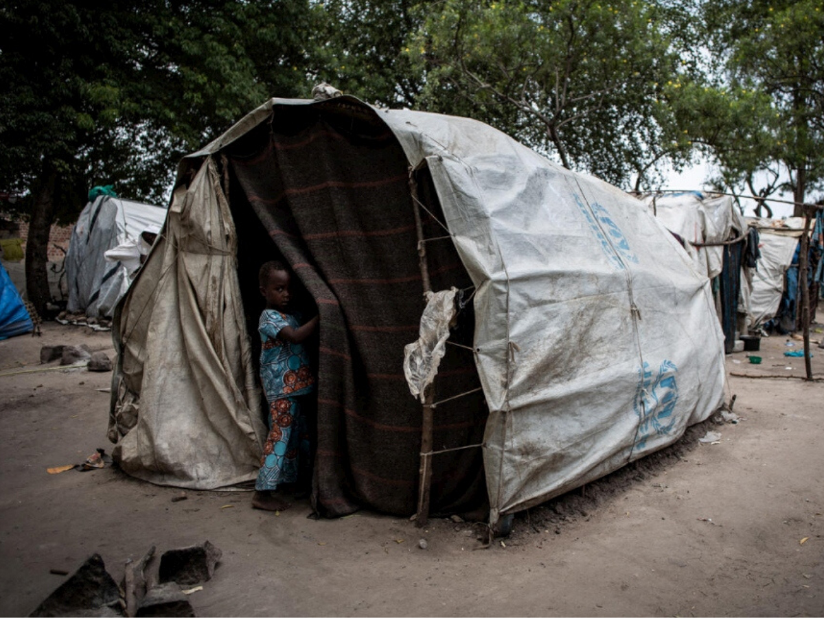 Un enfant se tient à l’entrée d’une tente dans un site de déplacés internes à Kasenyi, RDC