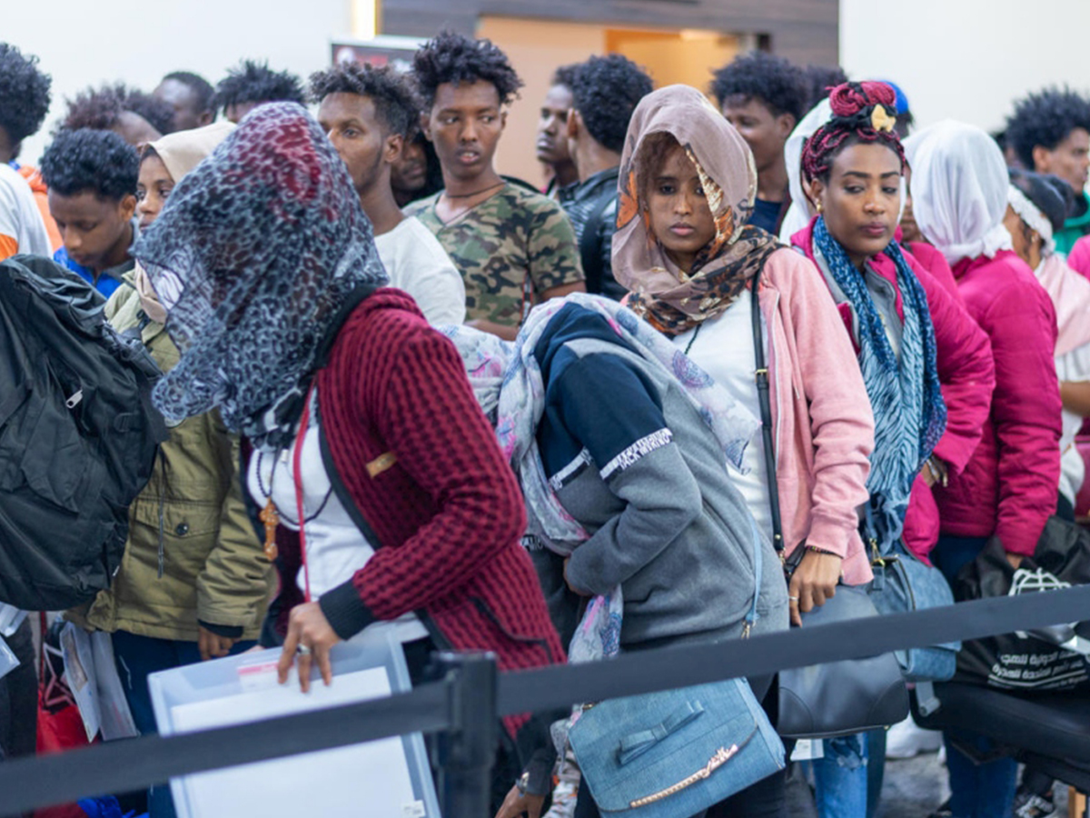 Refugees stand outside an airport