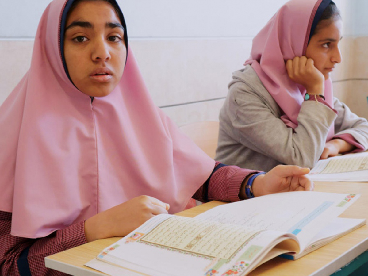 Two Afghan students sit at their desks