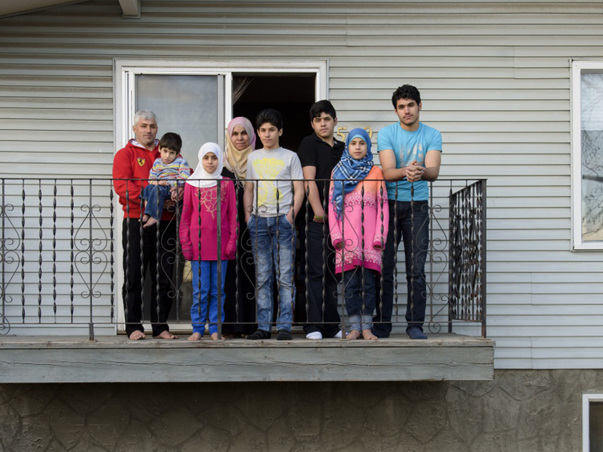 Les membres de la famille Al Kawarit posent sur le balcon de leur nouvelle maison à Calgary, où ils recommencent une nouvelle vie grâce à un programme mené par le Gouvernement canadien pour la réinstallation de réfugiés syriens