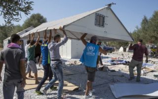 Le personnel du HCR, des volontaires grecs locaux et certains réfugiés syriens assemblent des abris temporaires du HCR parrainés par la fondation IKEA, qui ont été transportés par avion à Lesbos il y a 10 jours.