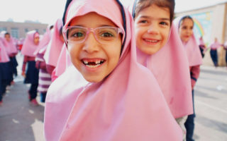 Deux soeurs réfugiées afghanes vivant en Iran dans l’une des files d’élèves avant d’entamer l’année scolaire
