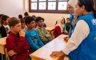 UNHCR staff talk to children