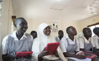 Des réfugiées utilisent des tablettes dans une salle de classe de l’école Angelina Jolie, au camp de réfugiés de Kakuma au Kenya. L’école est connectée à Internet depuis 2016 avec l’aide de la fondation Vodafone