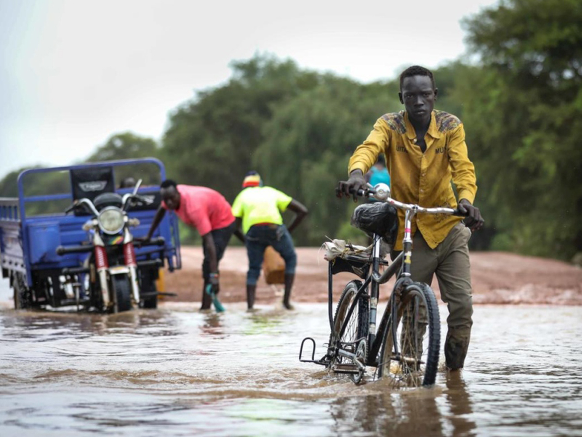 A man rides a bike through water in South Sudan