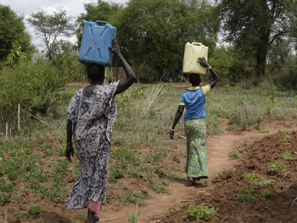 Zamurat (à gauche) et Zahabu transportent leurs jerrycans du point d'eau à leur domicile en Ouganda