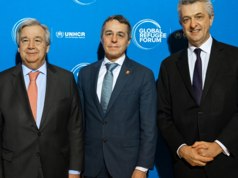Three men standing together at Global Refugee Forum