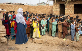 Des enfants réfugiés afghans dans la cour d’une école de fortune de l’installation 12-Secteur I à Islamabad au Pakistan