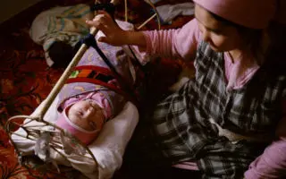 woman holding onto baby's crib