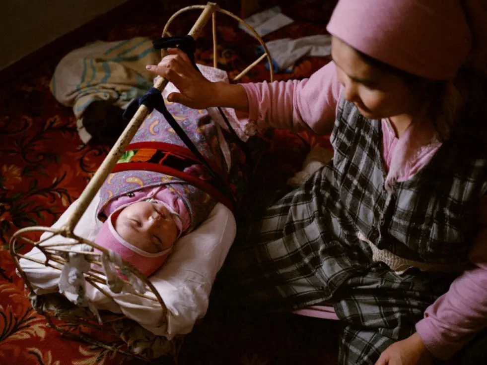 woman holding onto baby's crib