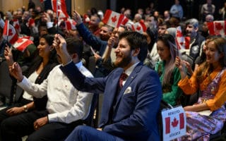 Le mercredi 15 janvier 2020, Tareq Hadhad, un réfugié syrien et le fondateur de Peace by Chocolate, agite un drapeau canadien avec 48 autres nouveaux Canadiens pendant sa cérémonie de citoyenneté canadienne au Quai 21 à Halifax (Nouvelle-Écosse).