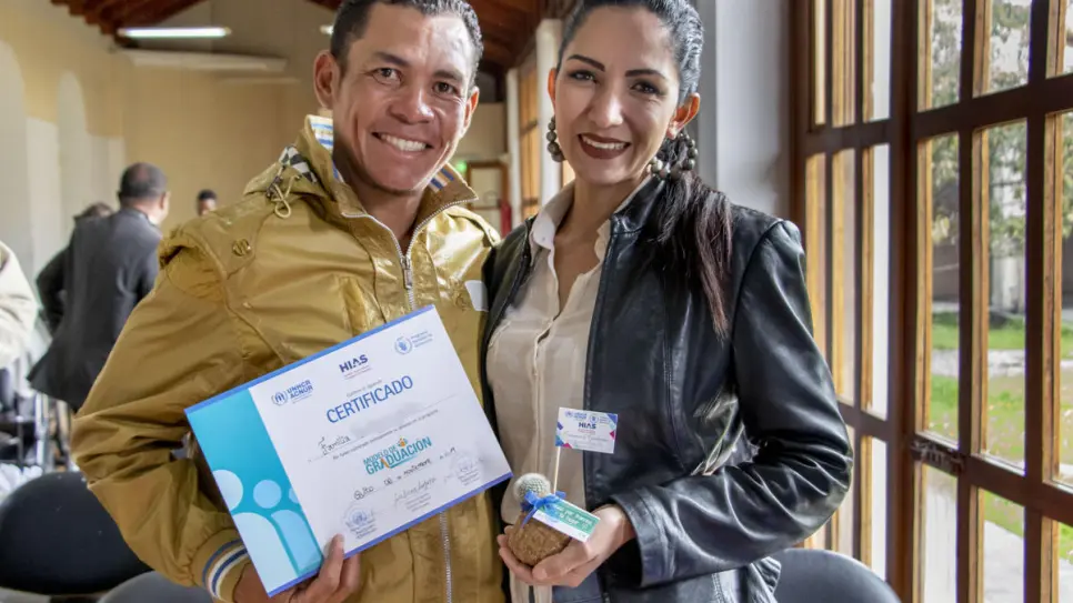 Two refugees hold certificate in Ecuador