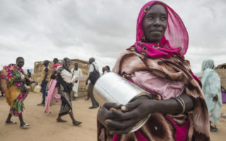 Refugee in Sudan holding pot