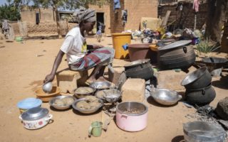 A woman cooks food outside in Burkina Faso