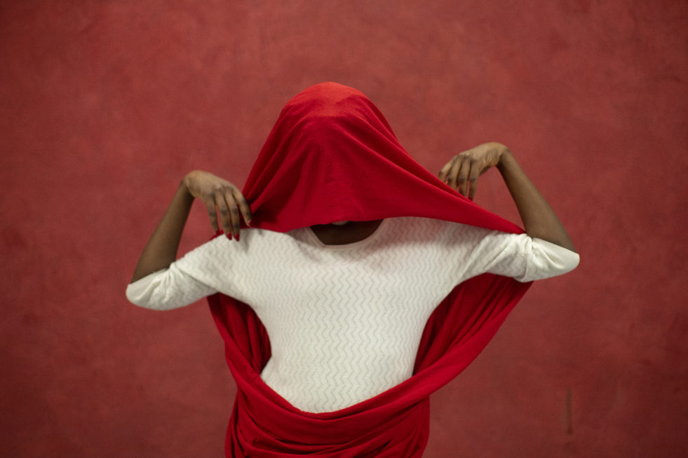 Ugandan refugee poses with a scarf over her face