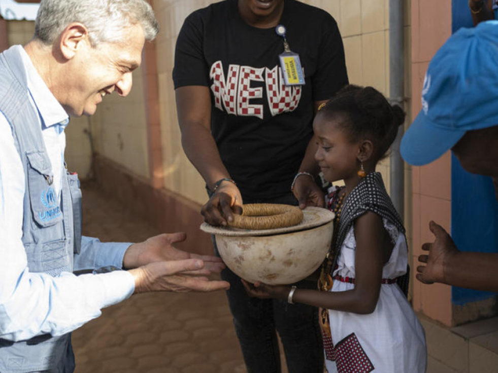 High Commissioner receives a bowl from a young girl in Burkina Faso