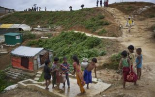 Rohingya children stand in line for a water pump