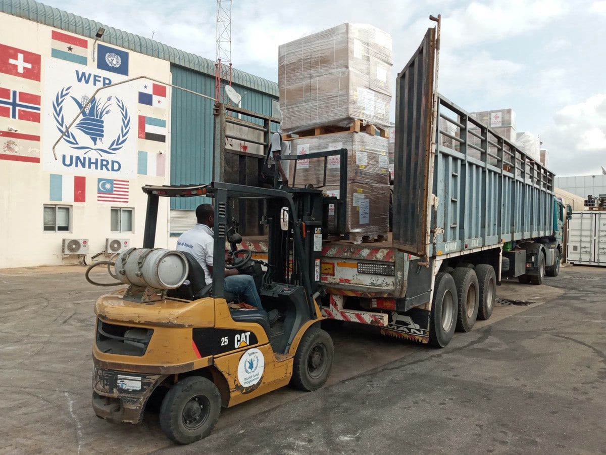 a forklift unloading boxes off of a large semi-truck