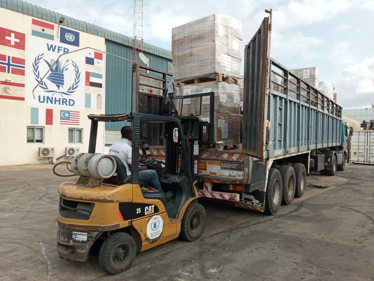 a forklift unloading boxes off of a large semi-truck