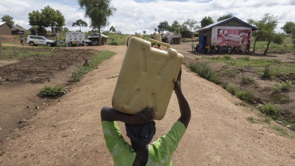 Asha Rose Sillah, une réfugiée sud-soudanaise transporte un bidon du point d’eau jusqu’à chez elle, dans le camp de réfugié de Bidibibi, en Ouganda