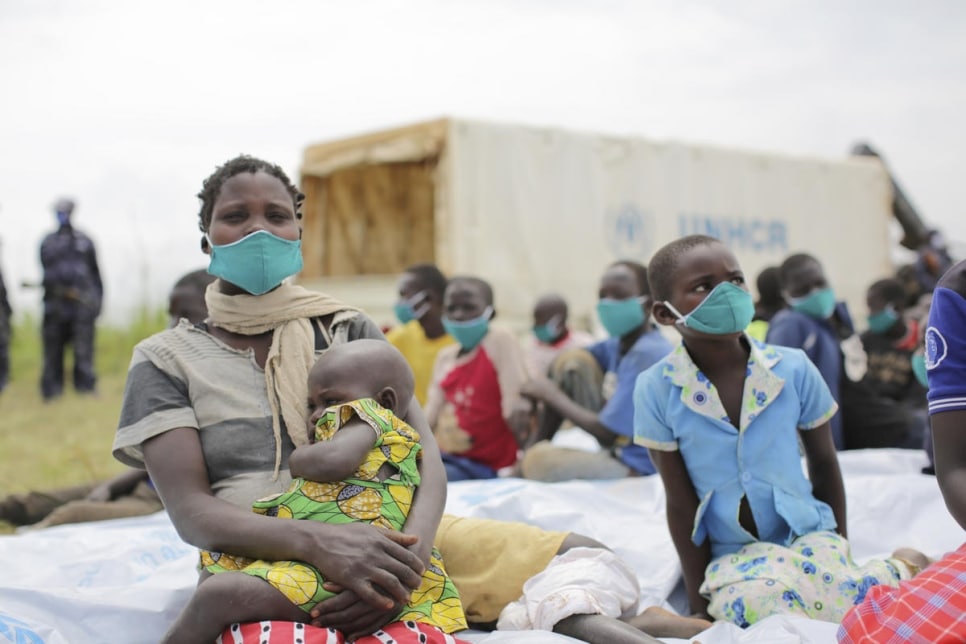 Anurith, une demandeuse d’asile de 29 ans originaire de la République démocratique du Congo (RDC), est assise avec ses enfants après avoir subi un examen médical près du poste frontière de Zombo, en Ouganda